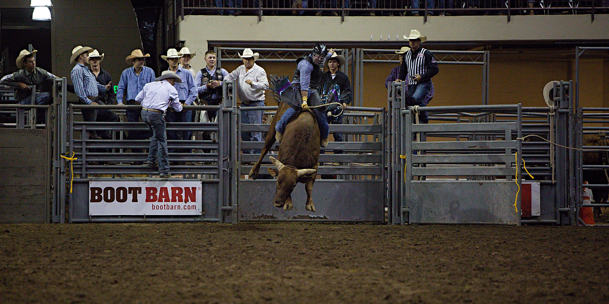 a man riding a bull in a arena